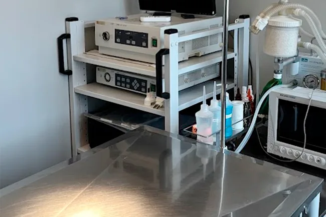 Monitores e equipamentos cirúrgicos em prateleira sobre a mesa de inox do centro cirúrgico