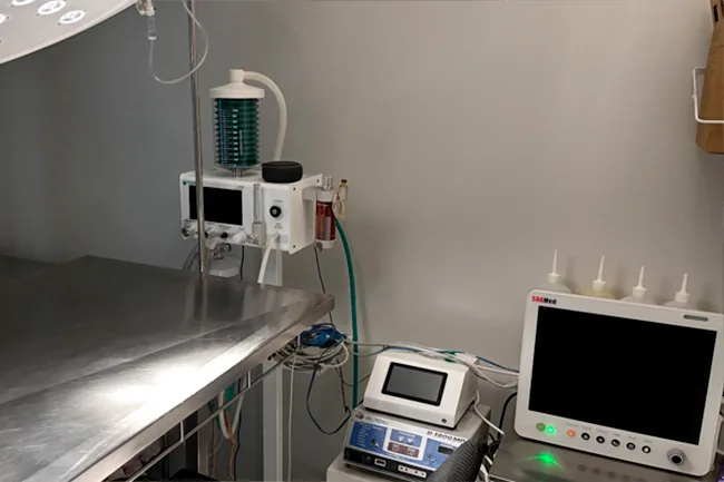 Aparelho de anestesia com vaporizador e monitor multiparamétrico ligado ao lado da mesa cirúrgica